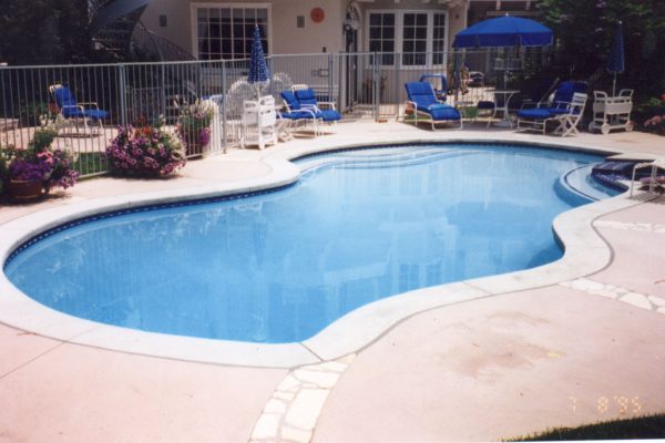 fenced-in-pool-with-lounge-chairs_riviera-pools-and-spas_premium-pool-builder-in-los-angeles-and-southern-california