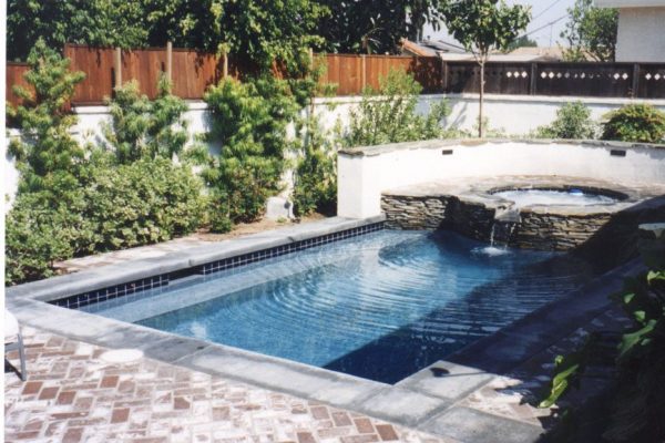 spa-with-waterfall-flowing-into-pool_riviera-pools-and-spas_premium-pool-builder-in-los-angeles-and-southern-california